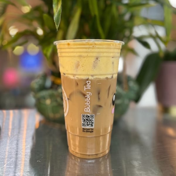 Iced coffee with a thick layer of yellow foam on top, from Bubbly Tea.